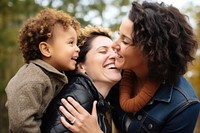 Lesbian couple laughing hugging adult. 