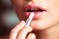 Cosmetics lipstick applying holding. 