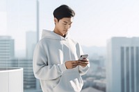 Asian man wearing casualwear holding phone city. 