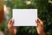 White card holding paper hand. 