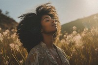 African woman in flower field with film grain effect