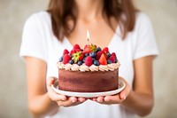 Birthday cake dessert holding cream. 