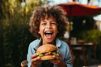 Eating laughing outdoors burger. 