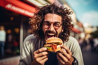 Outdoors biting eating burger. 