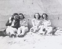 Women sitting against wall