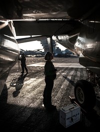 U.S. Navy Aviation Electronics Technician Airman Alison Guzik checks the exhaust of an E-2C Hawkeye aircraft assigned to Carrier Airborne Early Warning Squadron (VAW) 117, on the flight deck of the aircraft carrier USS Nimitz (CVN 68) Nov. 25, 2013, in the South China Sea. The Nimitz Carrier Strike Group was deployed to the U.S. 7th Fleet area of responsibility conducting maritime security operations and theater security cooperation efforts.