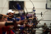 U.S. Air Force veteran Ryan Gallo, center, aims his bow in the archery qualification match during the 2014 Warrior Games in Colorado Springs, Colo., Oct. 1, 2014.