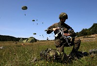 A Polish paratrooper with the 6th Polish Airborne Brigade, unpacks his backpack after parachuting out of a plane during exercise Swift Response, Hohenfels, Germany, Aug. 26, 2015.