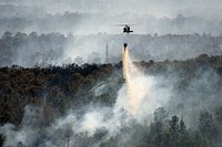 A Texas Army National Guard UH-60 Black Hawk out of the Austin Army Aviation Facility helps fight wildfires threatening homes and property near Bastrop, Texas, Oct. 14, 2015.