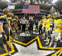 U.S. Army Gen. David G. Perkins, the commander of U.S. Army Training and Doctorate Command, flips a coin to determine which team will receive the ball first during the U.S. Army All-American Bowl at the Alamodome, in San Antonio, Jan. 9, 2016.