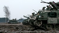 Bradley Fighting Vehicles assigned to Company C, 2nd Battalion, 70th Armored Regiment, 2nd Armored Brigade Combat Team, 1st Infantry Division, Fort Riley, Kansas, idle on the fields of Presidenski Range in Trzebian, Poland, during a platoon combined arms live fire exercise (CALFEX), March 26, 2018.