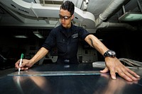 U.S. Navy Seaman Christopher Jackson, from Port St. Lucie, Florida, uses a marker to outine where to cut on sheet metal aboard the aircraft carrier USS George Washington (CVN 73) in the Atlantic Ocean, Oct. 25, 2016.