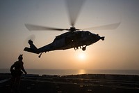 A U.S. Navy SH-60 Sea Hawk helicopter carrying Maritime Raid Force (MRF) Marines with the 24th Marine Expeditionary Unit hovers over the amphibious assault ship USS Bataan (LHD 5) during a fast-rope exercise in the U.S. 5th Fleet area of responsibility March 29, 2017.