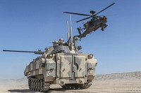 A U.S. Army AH-64 Apache helicopter assigned to the 1st Stryker Brigade Combat Team, 4th Infantry Division flies over an OPFOR Surrogate Vehicle during an engagement near the John Wayne Foothills, National Training Center, Fort Irwin, California, July 1, 2017.