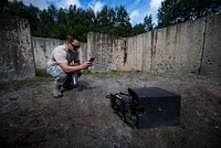 U.S. Air Force Senior Airman James Boyce, assigned to the 86th Civil Engineer Squadron Explosive Ordnance Disposal journeyman, takes a photo of a breached safe with his phone at the EOD training range on Ramstein Air Base, Germany, Aug. 9, 2017.