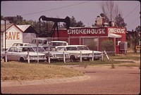 Oil Derrick beside Restaurant and Used Car Lot, 06/1972. Original public domain image from Flickr