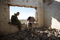 Australian trainer Sgt. Dave Devlin, (Left), assigned to the 4th Regiment, Royal Australian Artillery, waits for an Iraqi soldier to finish plotting points on his map before calling in air support during forward air control training at the Besmaya Range Complex, Iraq, Nov. 14, 2017.