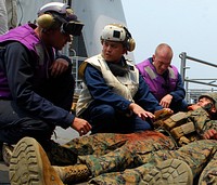U.S. Navy Hospital Corpsman 1st Class Jason Amos, center, diagnoses the injuries of a simulated landslide survivor during a casualty evacuation exercise aboard the dock landing ship USS Harpers Ferry (LSD 49) Aug. 6, 2009, while under way in the South China Sea for Cooperation Afloat Readiness and Training (CARAT) 2009.