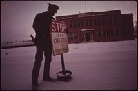 Patrolman Mark Shearer Puts Up School Crossing Signs at Daybreak. Lawbreaking in Rifle Is Mostly Confines to Traffic Violations and Occasional Drunkenness, 01/1973. Original public domain image from Flickr