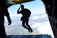U.S. Air Force Academy cadet Austin Martin, a member of the Academy's Wings of Blue Parachute Team, salutes while jumping from a U.S. Army CH-47 Chinook helicopter at Beale Air Force Base, California, April 26, 2018.