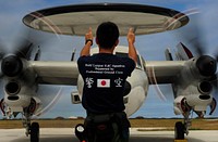 A Japanese Air Self-Defense Force E-2C Hawkeye aircraft crew chief from the 601st Squadron, Airborne Early Warning Group out of Misawa Air Base, Japan, directs an aircraft to a parking spot at Andersen Air Force Base, Guam, Feb. 18, 2010, during exercise Cope North.