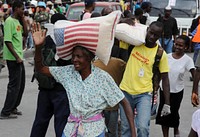 Earthquake victims in Haiti receive bags of rice from relief workers in front of the Presidential Palace in Port-au-Prince, Haiti, Jan. 25, 2010.