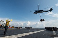 A U.S. Navy MH-60S Sea Hawk, with Helicopter Sea Combat Squadron (HSC) 14, prepares to offload pallets of cargo onto the flight deck aboard the Nimitz-class aircraft carrier USS John C. Stennis (CVN 74) during a replenishment-at-sea with the dry cargo and ammunition ship USNS Cesar Chavez (T-AKE 14) in the Pacific Ocean Nov. 30, 2018.