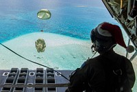 Royal Australian Air Force Sgt. Karl Penny, a C-130J Super Hercules loadmaster with the 37th Squadron out of RAAF Base Richmond, Australia, looks out as the parachute for a Low-Cost, Low-Altitude bundle carries humanitarian aid down to the atoll of Kapingamarangi, Federated States of Micronesia (FSM), during Operation Christmas Drop 2018, Dec. 13, 2018.