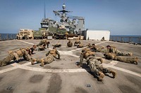 U.S. Marines with the 13th Marine Expeditionary Unit (MEU), perform burpees as a group during a physical training event for Martial Arts Instructor Course aboard the Whidbey Island-class dock landing ship USS Rushmore (LSD 47) in the Gulf of Aden Oct. 5, 2018.