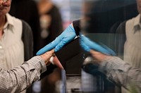 A traveler places his hand, left, on a device to take his fingerprints as officers with U.S. Customs and Border Protection Office of Field Operations receive international passengers at Dulles International Airport in Dulles, Va., March 13, 2020.