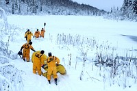 U.S. Air Force fire protection specialists assigned to the 673d Civil Engineer Squadron make their way to open water during ice rescue training at Six Mile Lake on Joint Base Elmendorf-Richardson, Alaska, Dec. 21, 2020.