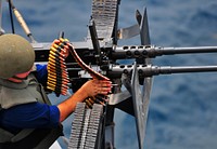 U.S. Navy Gunner's Mate 3rd Class Matthew Montalbano loads a .50-caliber machine gun during a small-craft action team (SCAT) exercise aboard the amphibious dock landing ship USS Pearl Harbor (LSD 52) while under way in the Arabian Sea Sept. 20, 2010.