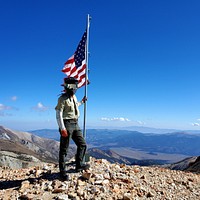 Summit Flag Humboldt oiyabe NF Christopher CoblerSpecial Use Permit Administrator Alex Van Raalte stands resolute with the American flag on the 20th anniversary of the September 11th attacks during the annual Eastern Sierra ATV Jamboree. September 11th, 2021.USDA Forest Service photo by Christopher Cobler.