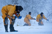 Karl Schultz, left, a firefighter for the 673d Civil Engineer Squadron, prepares an ice anchor during ice-rescue training at Sixmile Lake on Joint Base Elmendorf-Richardson, Alaska, Jan. 8, 2023. The JBER firefighters were certified as ice-rescue technicians after having learned and practiced the skills needed to conduct ice-rescue and recovery efforts. (U.S. Air Force photo by Airman 1st Class Julia Lebens)