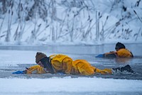 U.S. Air Force Staff Sgt. Joseph Jenkins, a fire protection specialist assigned to the 673d Civil Engineer Squadron, climbs out of icy water during ice rescue training at Six Mile Lake on Joint Base Elmendorf-Richardson, Alaska, Jan. 8, 2023. After completing a classroom course, the JBER firefighters took to the ice to test their skills in a series of scenarios designed to simulate real-world rescues. The firefighters received certifications as ice rescue technicians having qualified in the skills needed to conduct ice rescue and recovery efforts in extreme cold-weather environments. (U.S. Air Force photo by Senior Airman Class Patrick Sullivan)