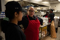 Chief culinary officer Martha Wiggins at Café Reconcile, right, mentors a trainee before the start of service in New Orleans, La., Feb. 16, 2023. Café Reconcile runs a volunteer program serving self-initiated youth ages 16-24 who reside in the Greater New Orleans area. Café Reconcile combines hands-on food service training with classroom instruction, individual case management, job placement services, and follow-up support to develop a participant’s ability to become independent, self-sufficient, and successfully employed. Featuring soul-filled local dishes, Café Reconcile is a destination lunch spot for a wide cross-section of New Orleanians as well as visitors from all across the country. Focusing on the kind of “soul food” for which New Orleans is known, the restaurant has earned high praise from local and national critics. The Supplemental Nutrition Assistance Program Employment and Training initiative offers SNAP recipients in Louisiana the opportunity to gain skills, training and work experience. The program is funded by the U.S. Department of Agriculture Food and Nutrition Service, and its goal is to help participants secure regular employment and achieve economic self-sufficiency. (USDA photo by Christophe Paul)  