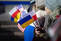 Attendees hold American, Polish, and Ukrainian flags as President Joe Biden delivers remarks, Tuesday, February 21, 2023, at the Royal Castle Warsaw in Warsaw, Poland. 