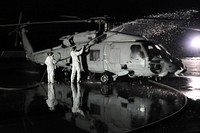 U.S. Sailors assigned to Helicopter Anti-submarine Squadron (HS) 14 and Helicopter Anti-Submarine Squadron Light (HSL) 51 rinse the exterior of an HH-60H Seahawk helicopter March 23, 2011, at Naval Air Facility Misawa, Japan, to remove potential radioactive contaminants following a humanitarian relief mission in support of Operation Tomodachi.