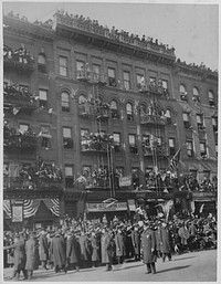Famous New York [African American] soldiers return home. Anxious crowds gathered in the streets, firescapes and roofs awaiting glimpse of 369th (old New York City [African American] 15th regiment) in its welcome home parade. Original public domain image from Flickr