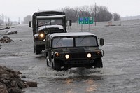 Minnesota Army National Guardsmen assigned to the 2nd Combined Arms Battalion, 136th Infantry drive through flood water April 16, 2011, on Minnesota State Highway 1 into Oslo, Minn. The town, located on the Red River of the North, is surrounded by water, so the National Guard is providing a safe method in and out of Oslo. (DoD photo by Tech. Sgt. Erik Gudmundson, U.S. Air Force).