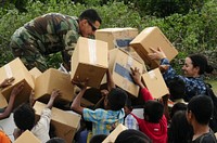 U.S. Navy Lt. Michael Sardone, left, and Lt. Cmdr. Jennie Goldsmith, right, load donated medical supplies into a truck during a community relations project in Zumalai, Timor-Leste, June 19, 2011, in support of Pacific Partnership 2011.
