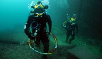 Chilean Navy divers 2nd Sgt. Bernardo Alcaide, left, and Petty Officer 2nd Class Roprigo Fuentas walk along the ocean floor during diving operations near Valparaiso, Chile, June 29, 2011.