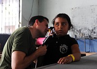 110630-F-ET173-099 - PUERTO SAN JOSE, Guatemala - (June 30, 2011) Peruvian Navy Cmdr. Mauricio Adrian checks a patient's ears at the Los Angeles surgical screening site in Puerto San Jose, Guatemala during Continuing Promise 2011 (CP11).