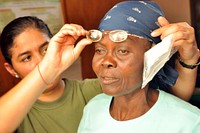 Colombian army ophthalmologist Maj. Enith Carcamo, left, fits a Haitian woman with a pair of glasses June 5, 2011, in Bocozelle, Haiti.
