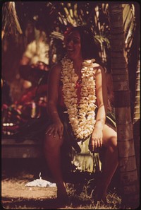 Hawaiian rests after demonstrating hula dance to appreciative Waikiki Beach tourists, October 1973. Photographer: O'Rear, Charles. Original public domain image from Flickr