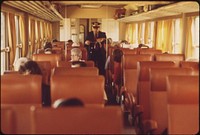 Conductor makes his rounds taking tickets as the turboliner makes its way between St. Louis, Missouri, and Chicago, Illinois, June 1974. Photographer: O'Rear, Charles. Original public domain image from Flickr