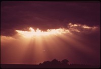 Sun rays through storm clouds over Grafton, in the farmlands west of Lincoln, May 1973. Photographer: O'Rear, Charles. Original public domain image from Flickr