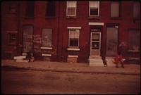 Two Men Sit Silently On Stoops Of Abandoned North Philadelphia Houses, August 1973. Photographer: Swanson, Dick. Original public domain image from Flickr