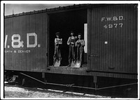 Three young boys with shovels standing in doorway of a Fort Worth & Denver train car, 1912. Photographer: Hine, Lewis. Original public domain image from Flickr