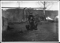Shorpy; a greaser on the tipple at Bessie Mine, Alabama. Carries two heavy pails of grease and is often in danger of being run over by the cars, November 1910. Photographer: Hine, Lewis. Original public domain image from Flickr